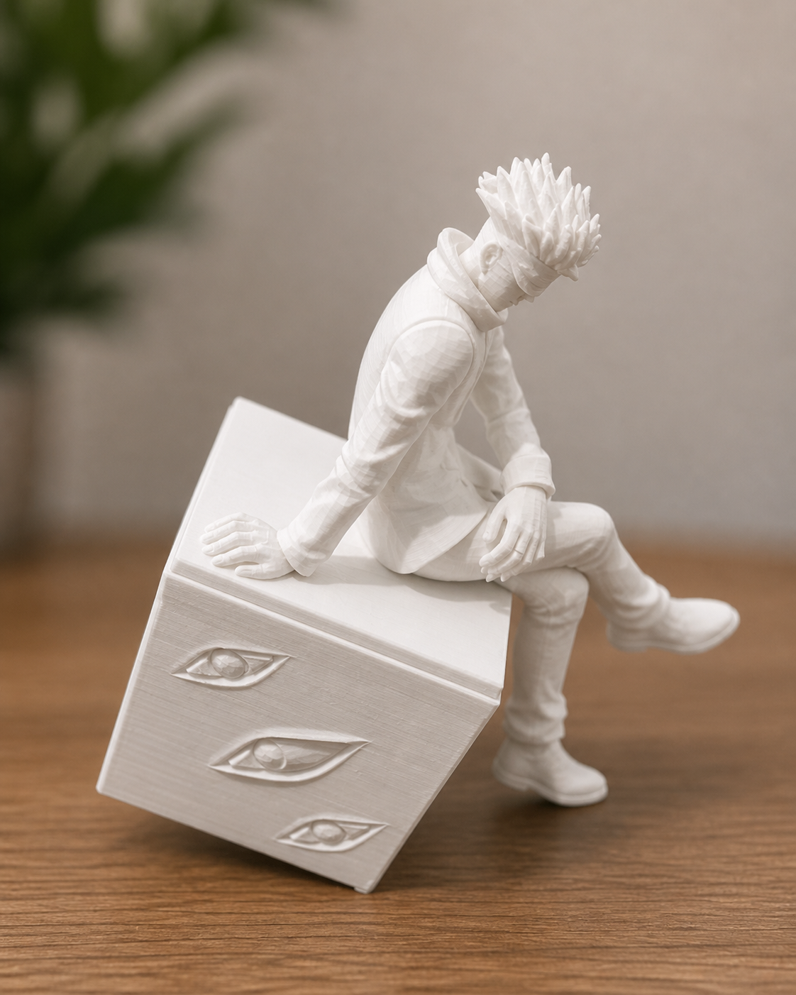 White anime character figurine sitting on a cube with eye motifs